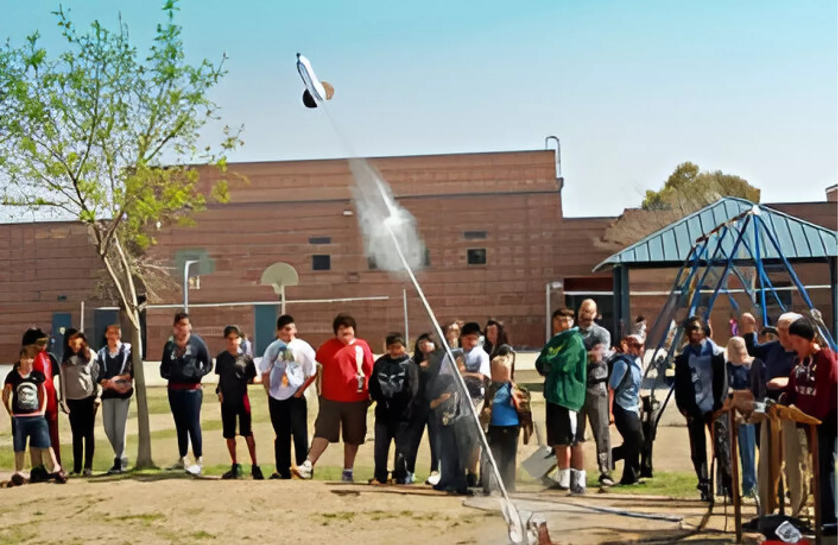 Students launching a model rocket outdoors.